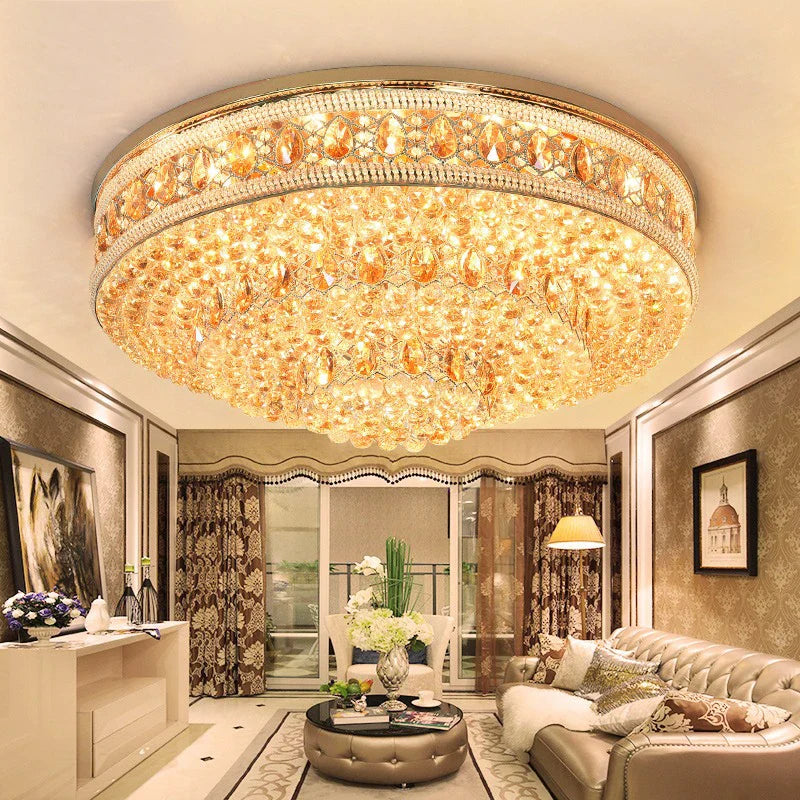 a chandelier light on the ceiling of the house with sofa sets, tables, other lights, wall art , door, curtains also visible in the picture