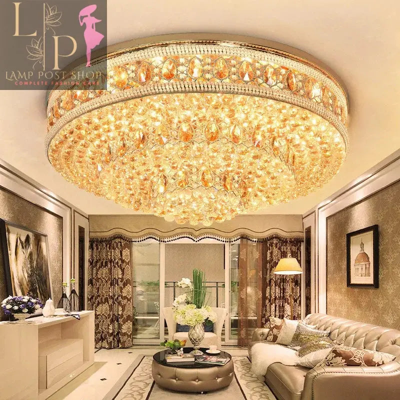 a chandelier light on the ceiling of the house with sofa sets, tables, other lights, wall art , door, curtains also visible in the picture