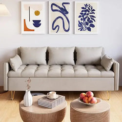 silver color 3 seats sofa with three different wallart, two tables and books on the table