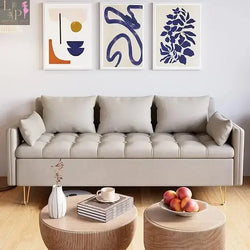 silver color 3 seats sofa with three different wallart, two tables and books on the table