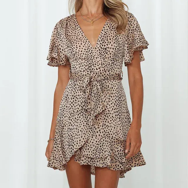 Light apricot summer V-neck ruffle dress for women by Lamp Post, shown on a model with flowing fabric and floral background.