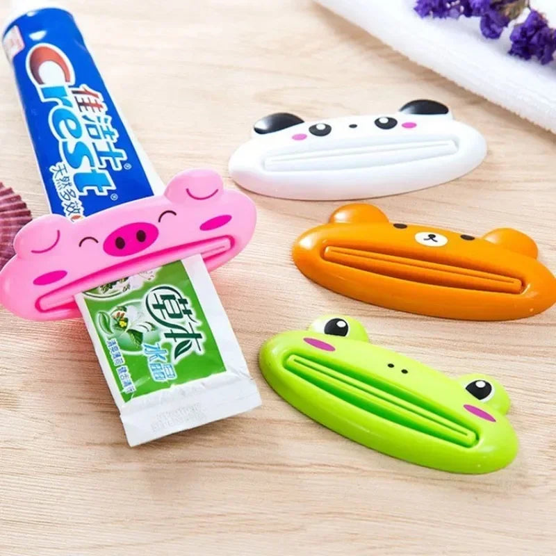Pink cartoon rolling toothpaste squeezer dispenser by Lamp Post, a fun bathroom tool for kids to easily squeeze toothpaste from tubes.