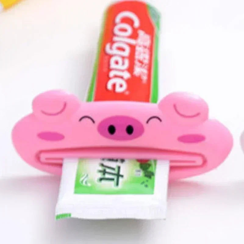 Pink cartoon rolling toothpaste squeezer dispenser by Lamp Post, a kid-friendly bathroom tool for easy toothpaste tube squeezing.