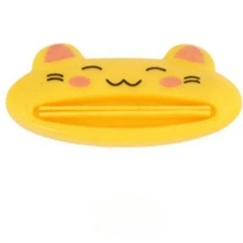 Pink cartoon rolling toothpaste squeezer dispenser by Lamp Post, a fun kid's bathroom tool for easy toothpaste tube squeezing.