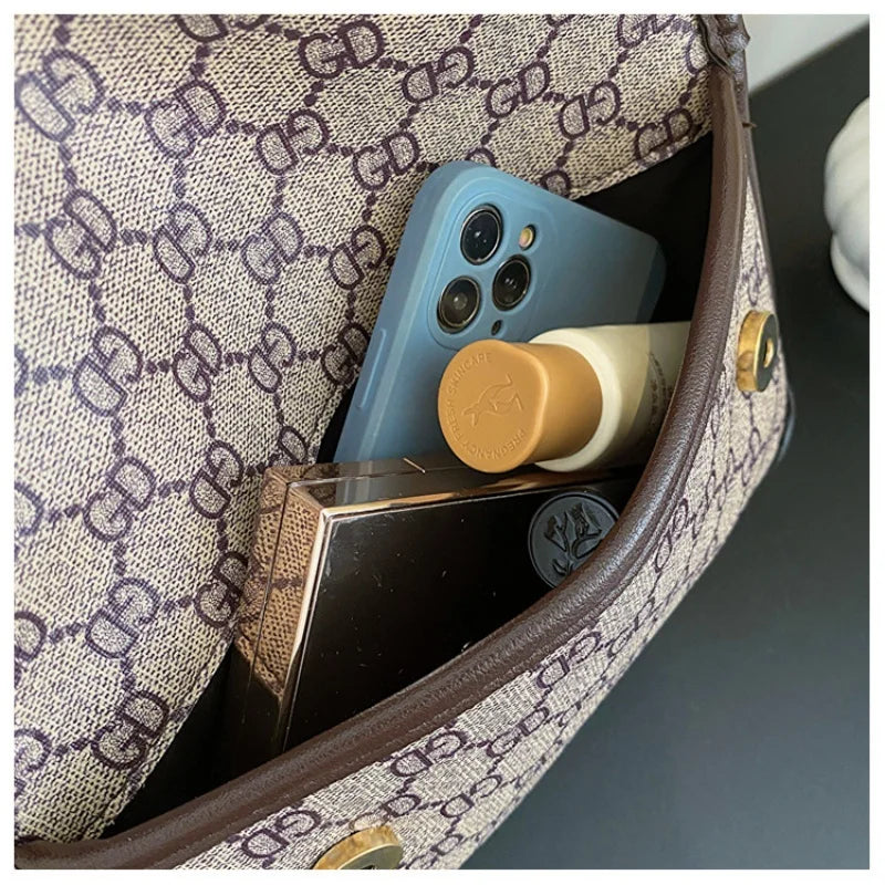 Lamp Post brown geometric print quilted shoulder bag with metal logo, lightweight PU material, flap closure, and adjustable strap.
