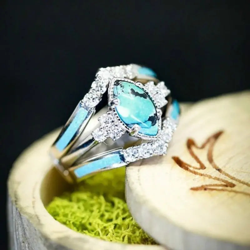 Women’s green stone ring set by Lamp Post, featuring multiple gold-tone rings with vibrant green gemstones for elegant style.
