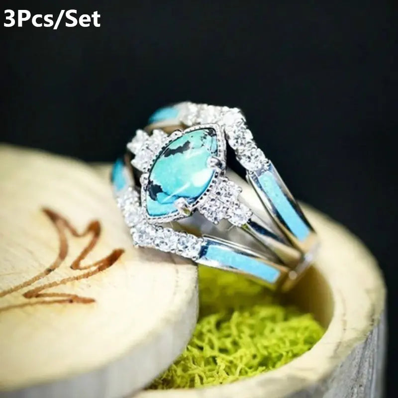 Women’s green stone ring set by Lamp Post featuring multiple gold-tone rings with vibrant green gemstones.