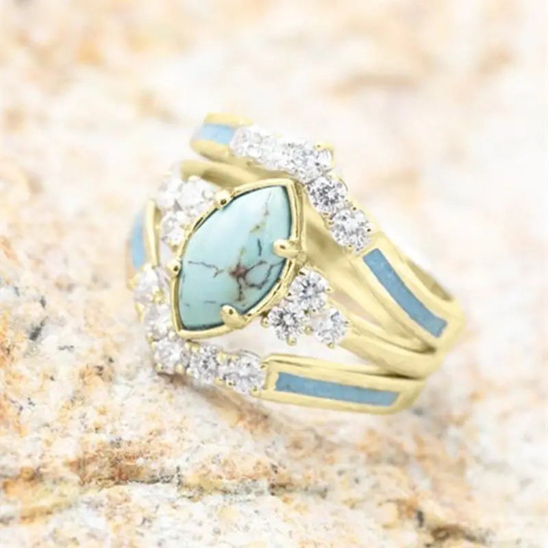 Women’s green stone ring set by Lamp Post featuring multiple gold-tone rings with vibrant green gemstones.