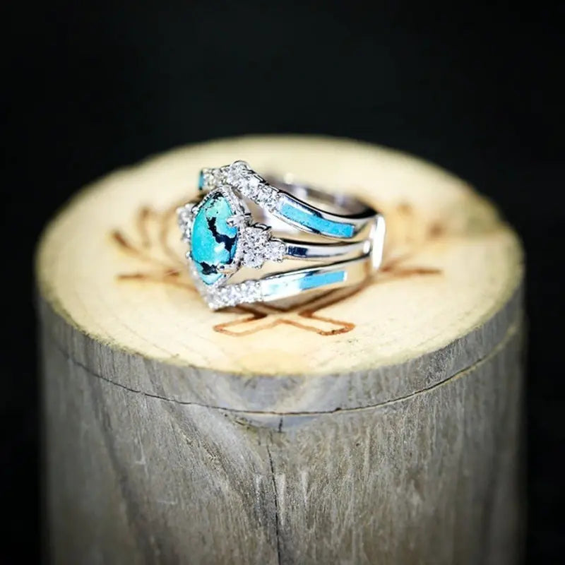 Women’s green stone ring set by Lamp Post, featuring multiple gold-tone rings with vibrant green gemstones.