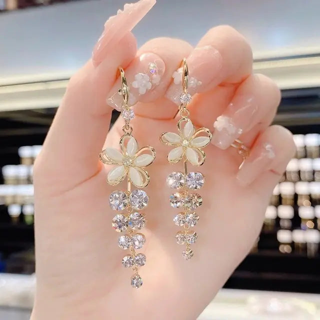 Gold flower earrings set by Lamp Post featuring delicate floral designs and elegant dangle style.