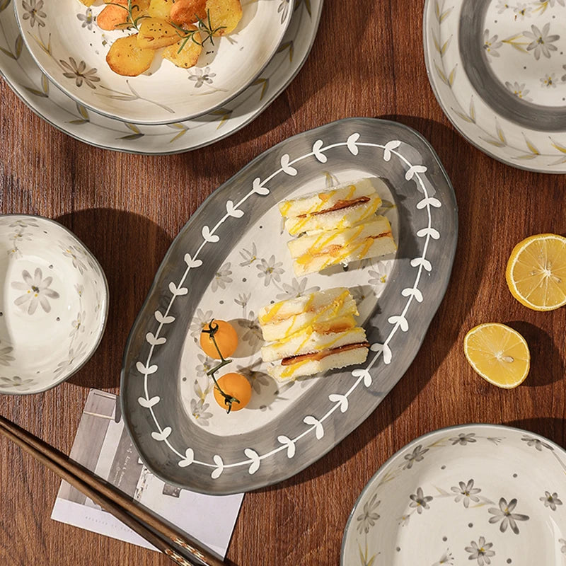 Lamp Post ceramic dining set with full dish cookware, including plates, bowls, and mugs, arranged on a kitchen table.