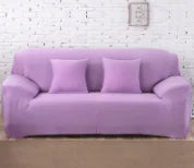 Lavender colorful sofa covers by Lamp Post draped over a sofa, showcasing vibrant, protective furniture covers in a cozy living room setting.