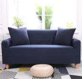 Lavender colorful sofa cover by Lamp Post drapes over a sofa, showcasing vibrant, decorative fabric in a cozy living room setting.