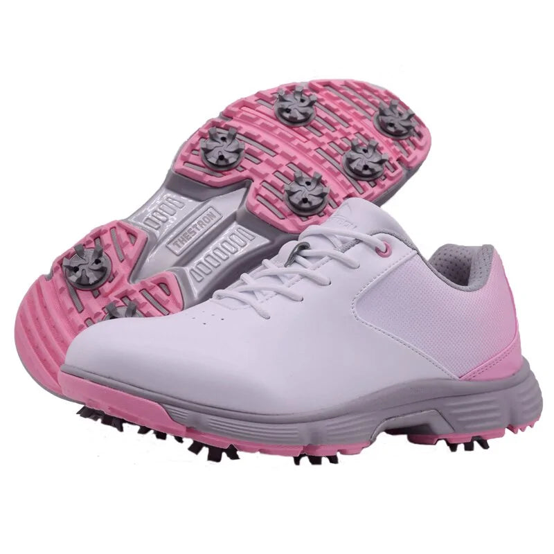 Pink women's outdoor spikes golf sneakers by Lamp Post with breathable mesh and rubber sole for outdoor golf courses.
