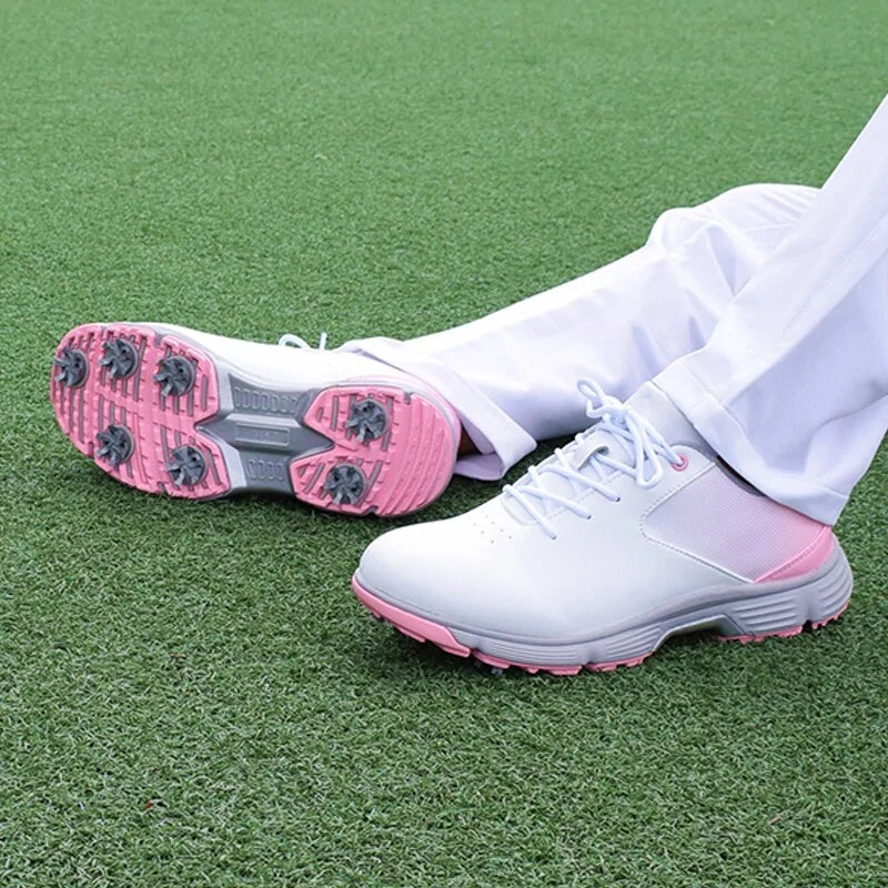 Pink women's outdoor spikes golf sneakers by Lamp Post with breathable design and spiked soles for better grip on the course.