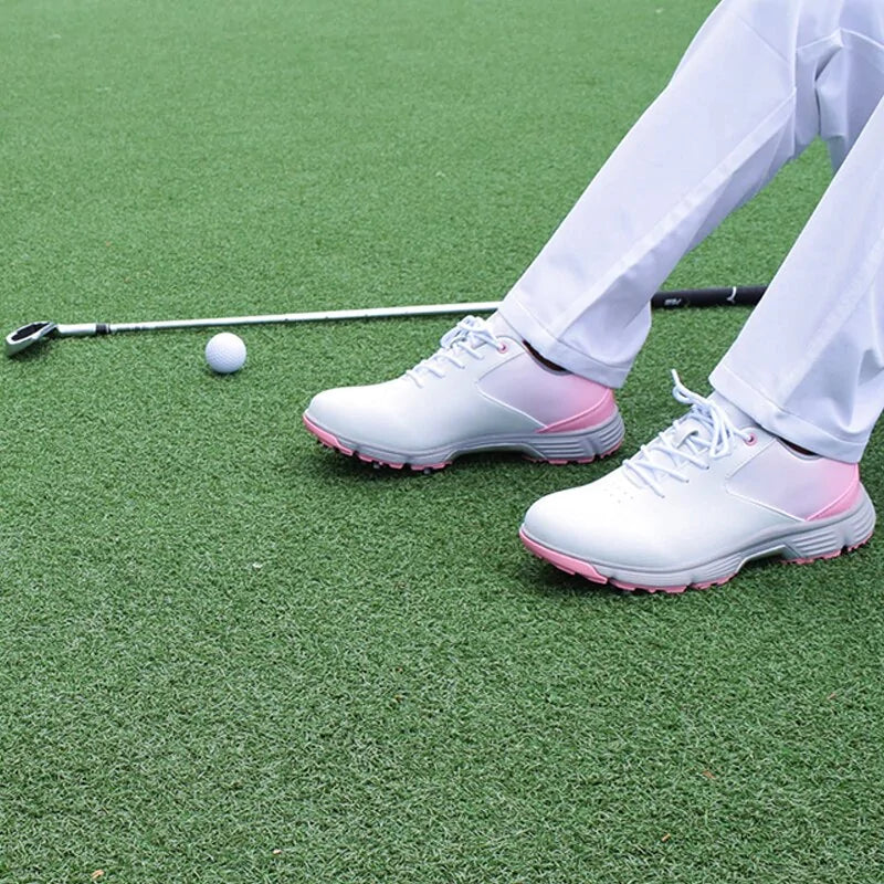 Pink women’s outdoor spikes golf sneakers by Lamp Post, featuring breathable fabric and spiked soles for better traction on the course.