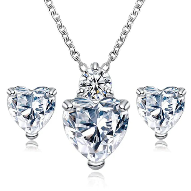 Women’s pink crystal jewelry set featuring heart-shaped earrings and necklace by Lamp Post. Elegant and sparkling jewelry for women.