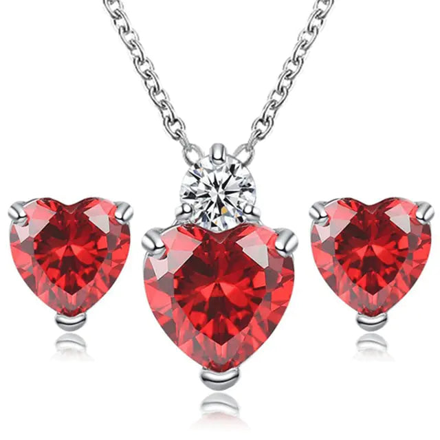 Women’s pink crystal jewelry set by Lamp Post featuring a heart-shaped necklace and matching earrings.