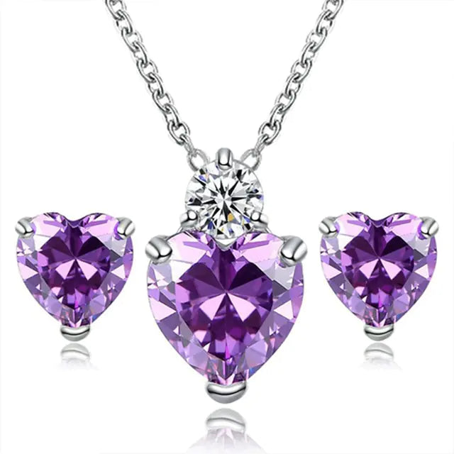 Women’s pink crystal jewelry set by Lamp Post, featuring a heart-shaped necklace and matching earrings with sparkling crystals.