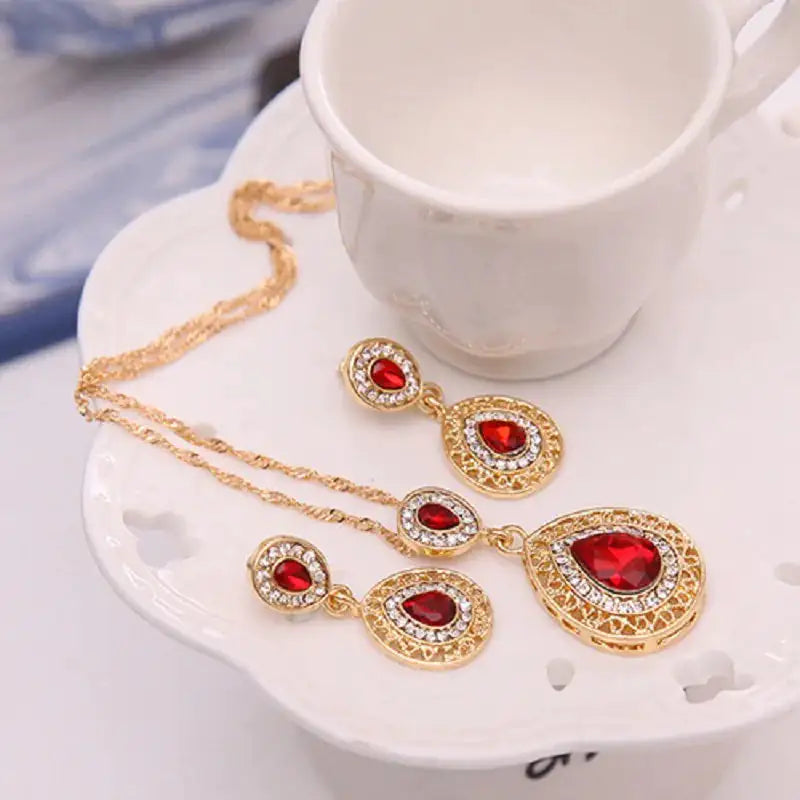 Red women jewelry set by Lamp Post featuring matching necklace and earrings with elegant design.