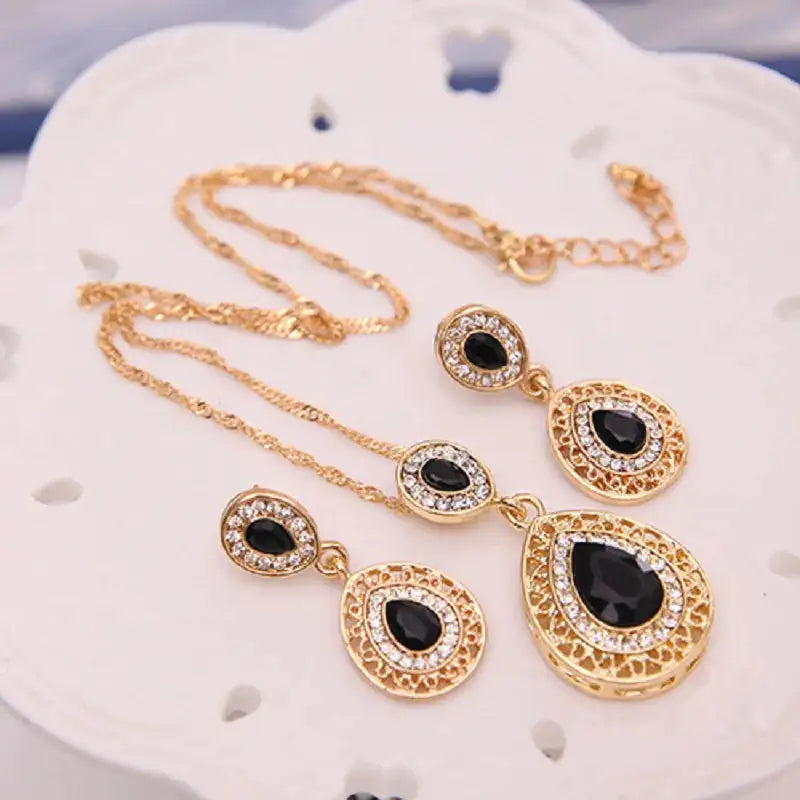 Women jewelry set by Lamp Post featuring a red necklace and matching earrings, displayed on a neutral background