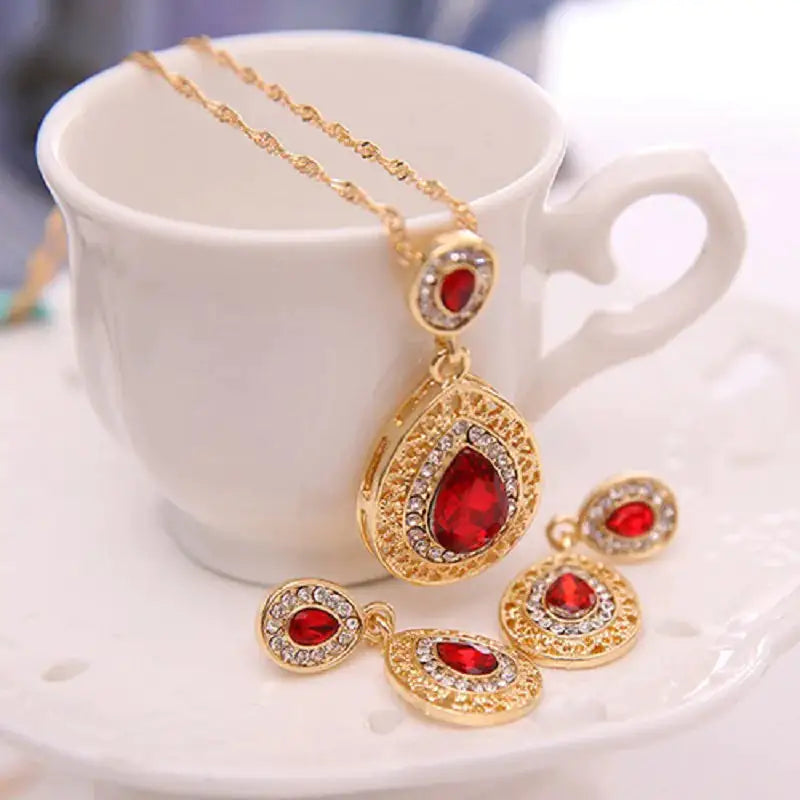 Red women jewelry set by Lamp Post featuring earrings and necklace with intricate design for stylish accessorizing.