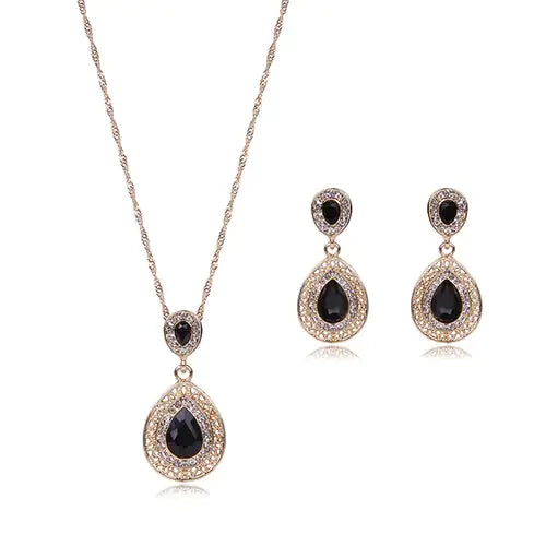 Red women jewelry set by Lamp Post featuring matching necklace and earrings displayed on a white background.