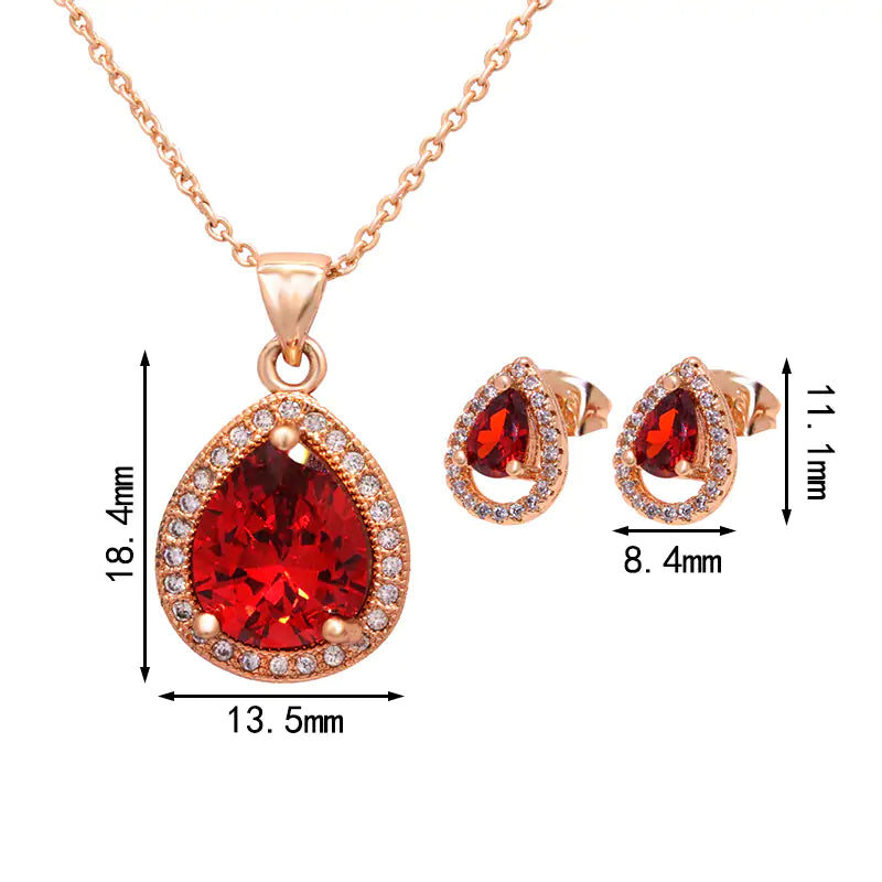 Red women jewelry set by Lamp Post featuring earrings, necklace, and bracelet with elegant design and silver accents.