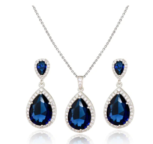 Red women jewelry set by Lamp Post featuring earrings, necklace, and bracelet with elegant design.