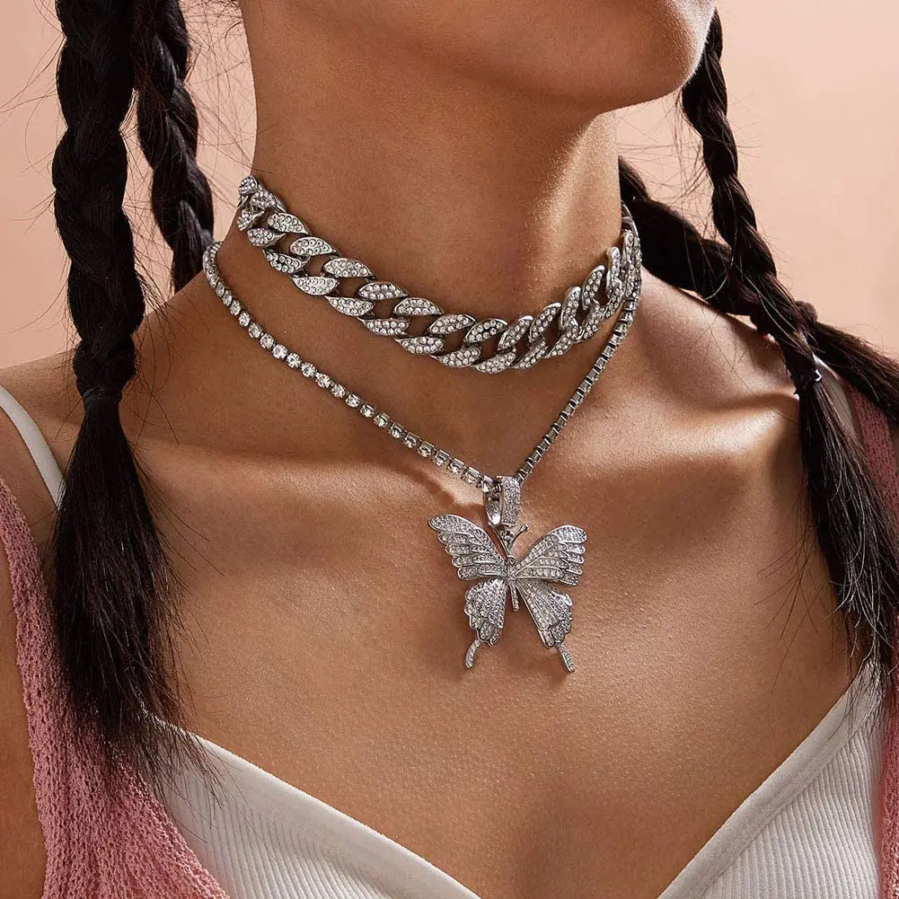 Silver women charm necklace set by Lamp Post featuring layered chains and delicate charm pendants on a neutral background.