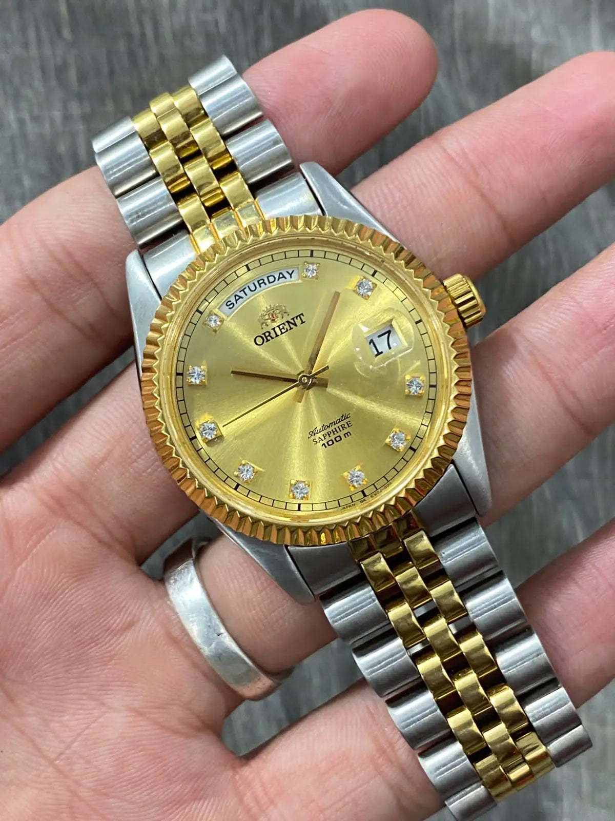 Gold Lamp Post men's luxury watch with a sleek design and metallic finish, displayed against a dark background.
