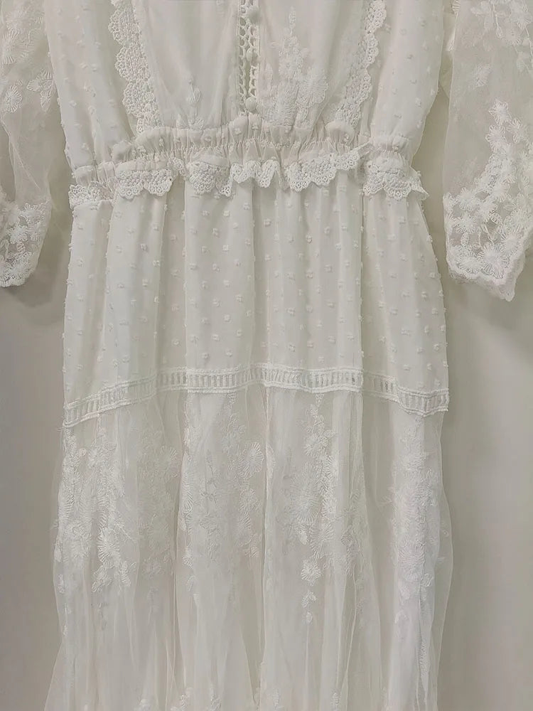 White women's long dress by Lamp Post, flowing fabric and elegant design, displayed on a hanger.