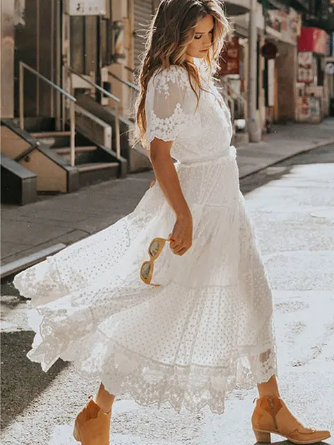 White women's long dress by Lamp Post, flowing and elegant, displayed on a hanger against a neutral background.