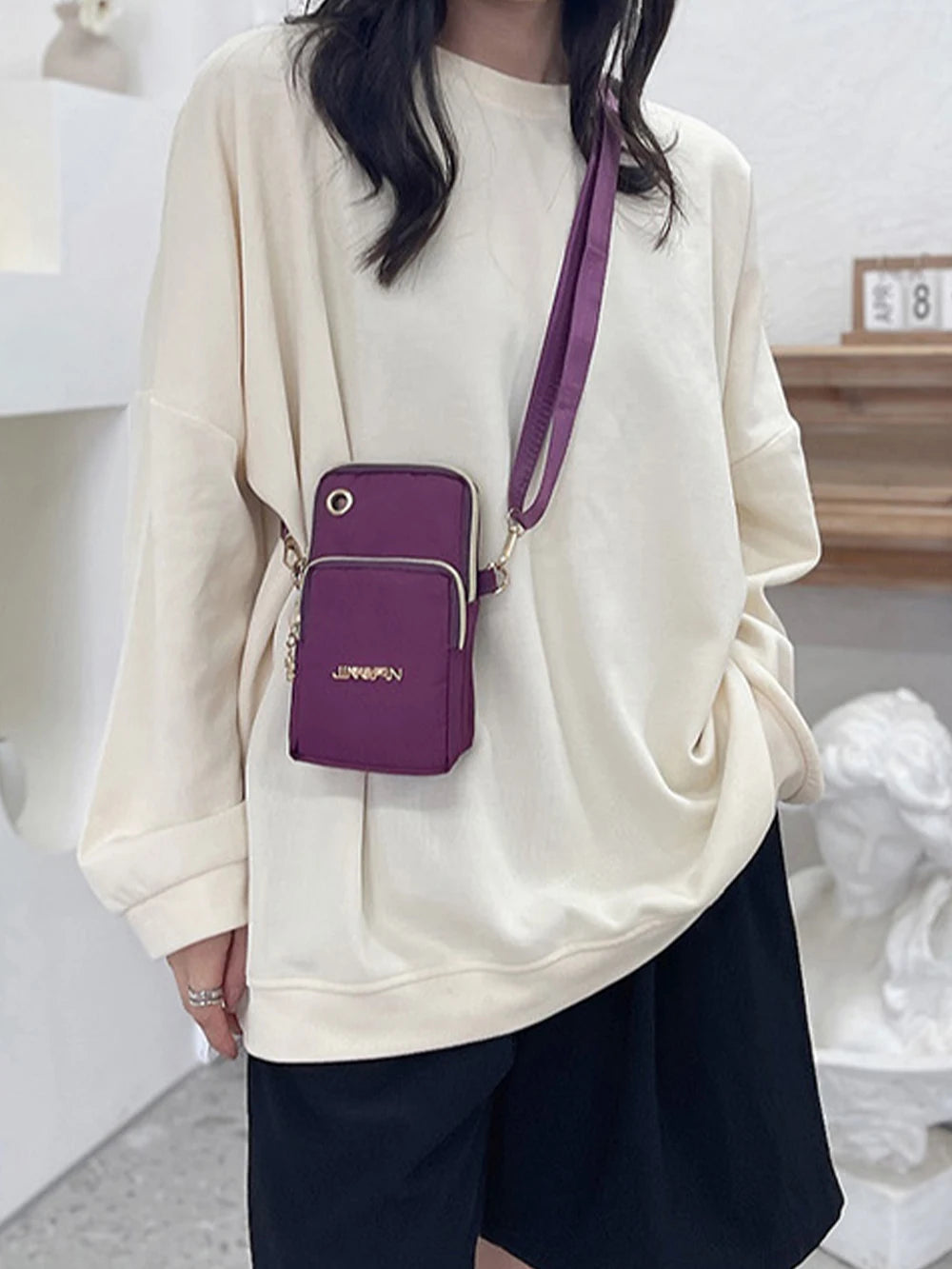 Lamp Post women's black crossbody mini bag for phones, with coin pocket, neck hanging design, suitable for running or daily use.