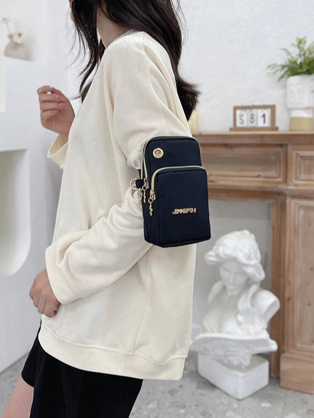 Black Lamp Post women's crossbody mini bag with adjustable strap, phone compartment, and coin pocket, suitable for running and daily use.