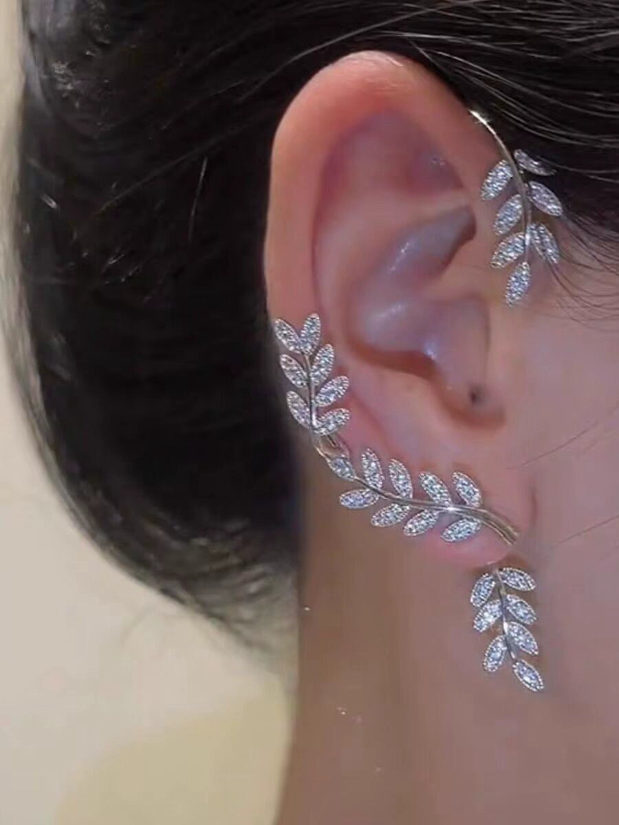 Gold female stud earrings with leaf design, hanging on the left ear, by Lamp Post, stylish women's ear rings.