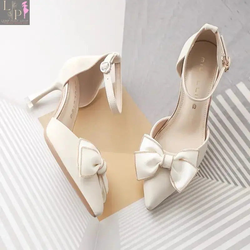 Elegant white women's heels, dress shoes suitable for weddings and bridal parties, with a sleek design and beige accents.